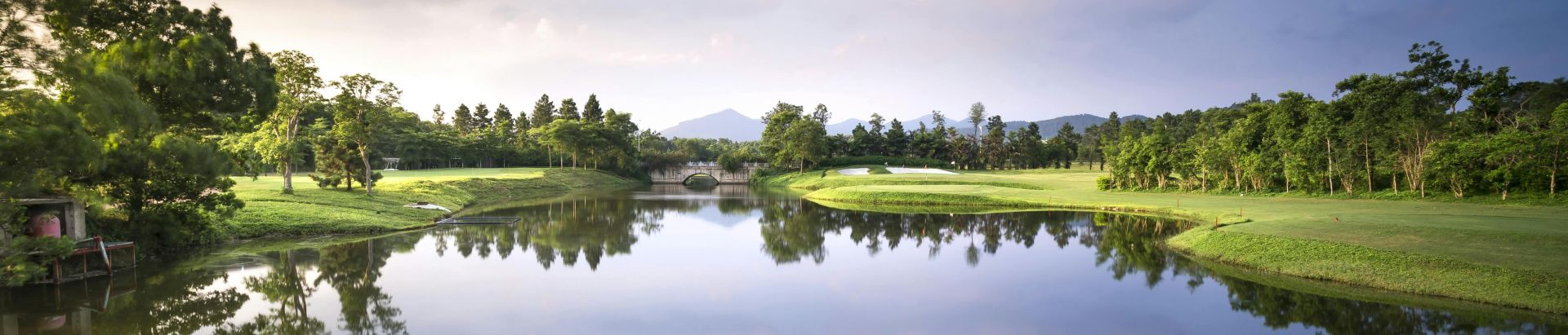 Peaceful golf course landscape with a reflective lake and serene surroundings.